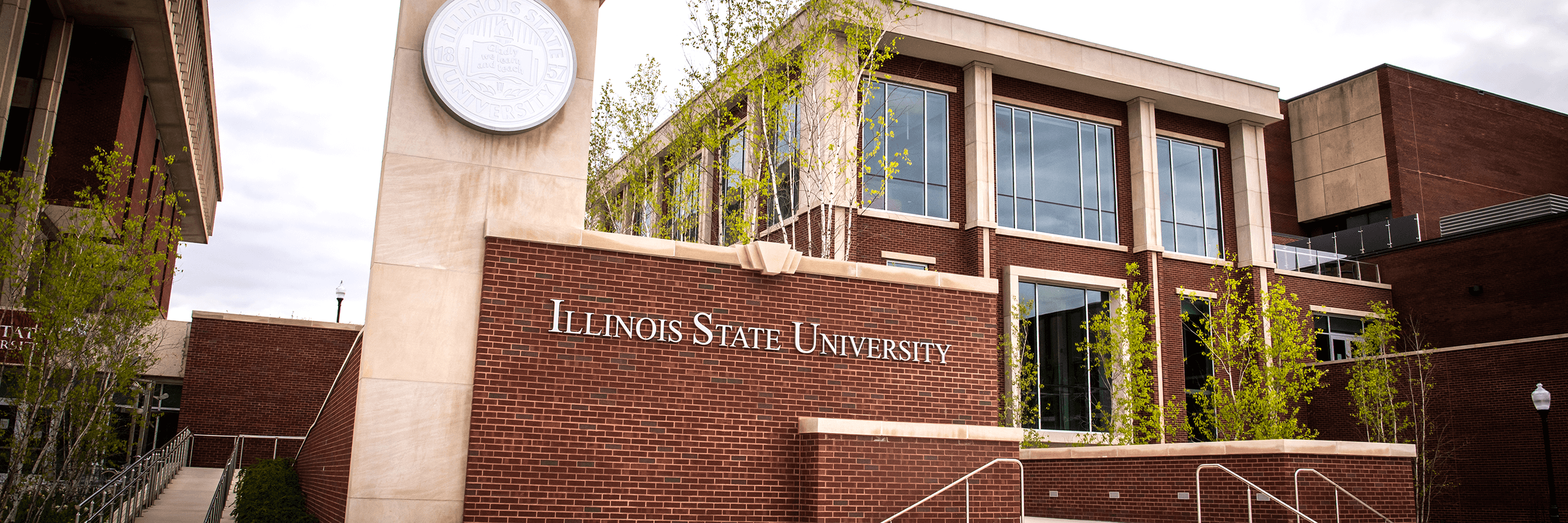 Red brick building of Illinois State University with large windows and a stone sign.